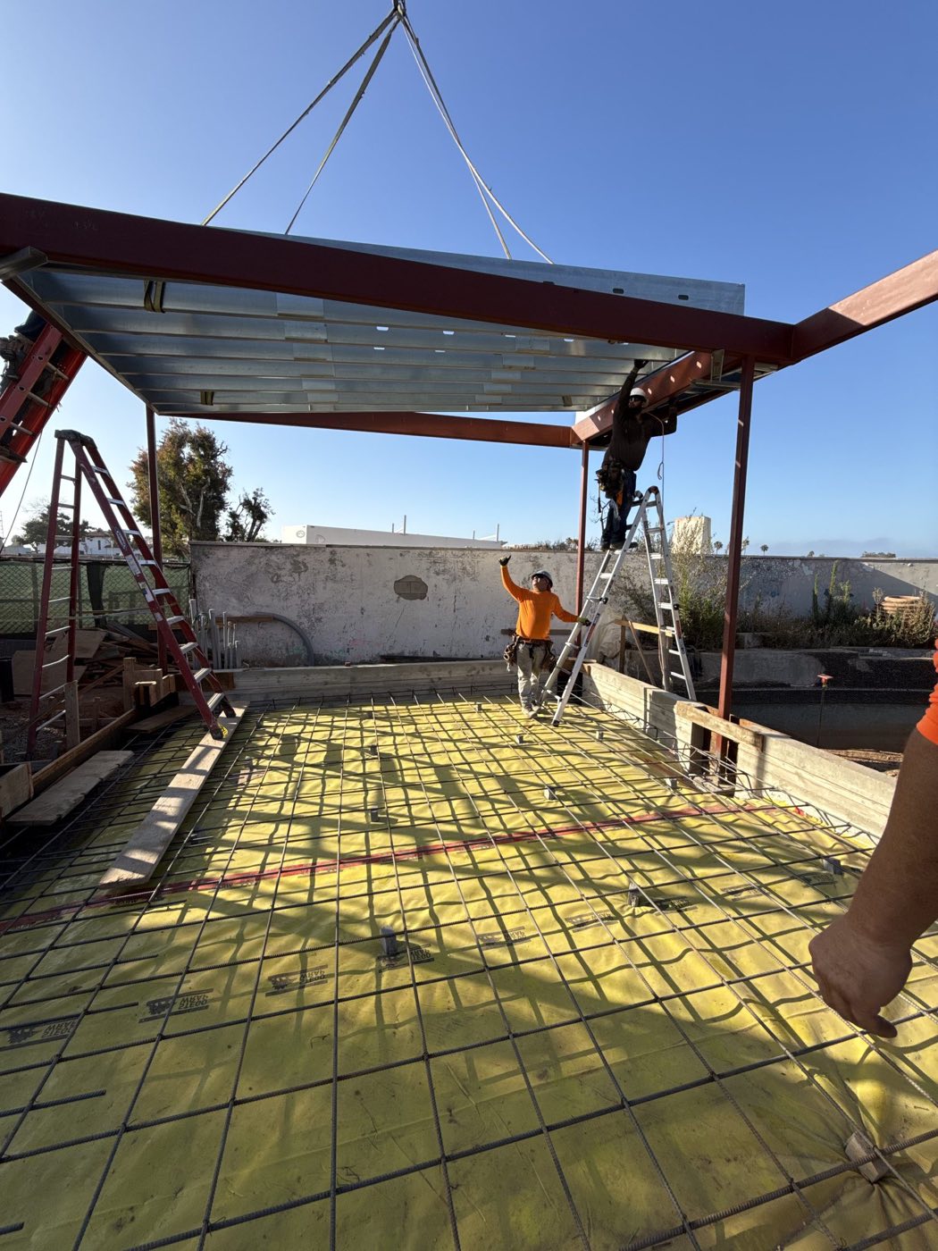 A crane setting a structural steel beam into place on the Palisades rebuild